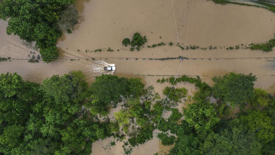 En bil kører i den oversvømmede østlige del af Kentucky torsdag. Området er ramt af oversvømmelser og mudderskred. Indtil videre er otte mennesker fundet døde, men antallet af dødsofre kan ende med at blive tocifret, siger delstatens guvernør. <i>Ryan C. Hermens/Ritzau Scanpix</i>