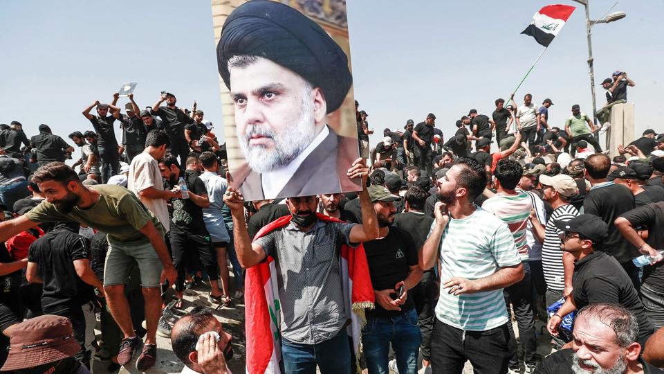 Støtter af Moqtada al-Sadr på vej mod parlamentet, efter at de har væltet muren ind til den såkaldte grønne zone i Bagdad. <i>Ahmad Al-Rubaye/Ritzau Scanpix</i>