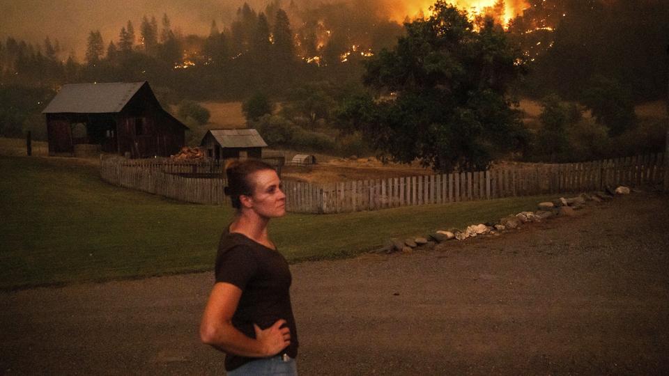Angela Crawford kigger på den største skovbrand, Californien har set i 2022. Den brænder på en bakke tæt på hendes hjem i delstaten på den amerikanske vestkyst. <i>Noah Berger/Ritzau Scanpix</i>