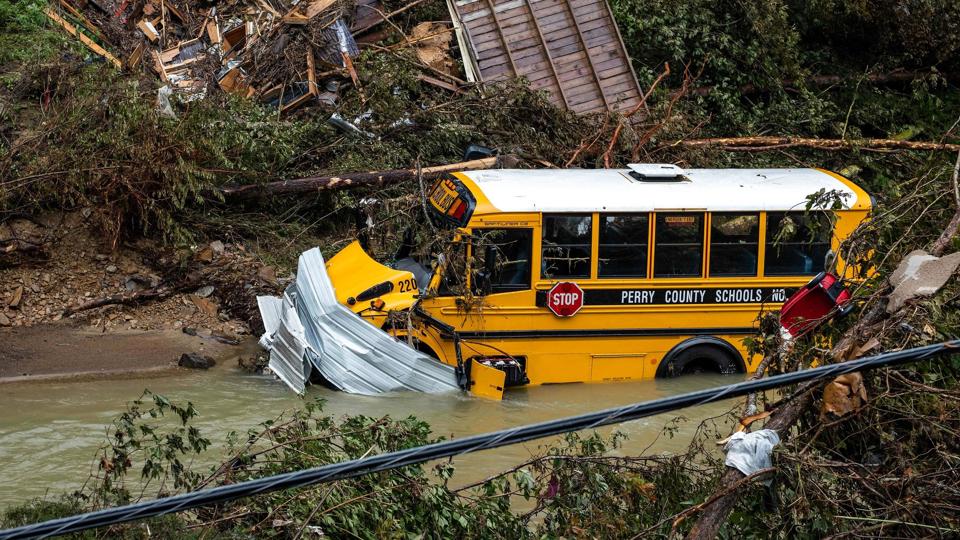 En gul skolebus sidder fast i et vandløb tæt ved byen Jackson i Kentucky, der er ramt af alvorlige oversvømmelser - og mere regn kan være på vej. <i>Seth Herald/Ritzau Scanpix</i>