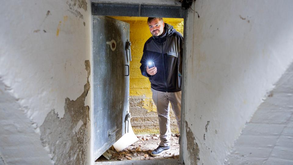 Historiker Thor Bæch Pedersen står ved indgangen til en skjult tidslomme, som fascinerer på hans guidede ture om Anden Verdenskrig.  <i>Foto: Henrik Bo</i>