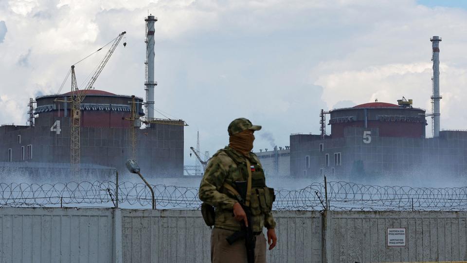 En soldat med et russisk flag på sin uniform holder vagt nær atomkraftværket udenfor den russisk kontrollerede by Enerhodar i det sydøstlige Ukraine. <i>Alexander Ermochenko/Reuters</i>