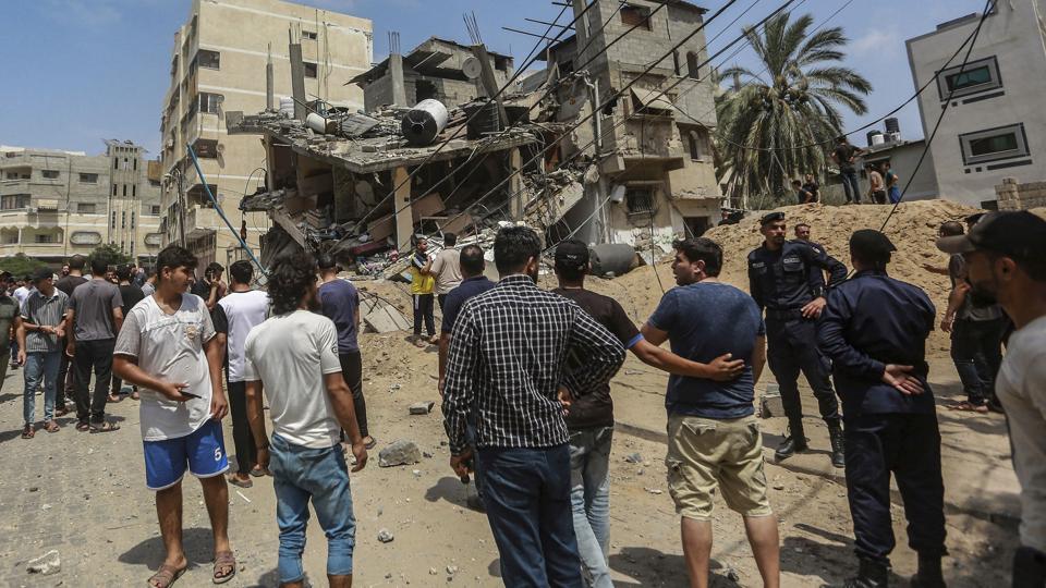 Palæstinensere i Gaza City betragter lørdag nogle af skaderne i byen, efter at Israel har foretaget en række luftangreb som svar på militante gruppers affyring af raketter mod Israel. Den israelske militæroperation er ikke slut, siger brigadegeneral. <i>Mohammed Talatene/Ritzau Scanpix</i>
