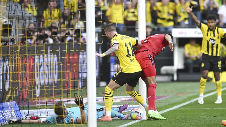 Marco Reus hjælper bolden over stregen til 1-0, efter at Lukas Hradecky i første omgang havde reddet forsøget fra Karim Adeyemi. <i>Bernd Thissen/Ritzau Scanpix</i>