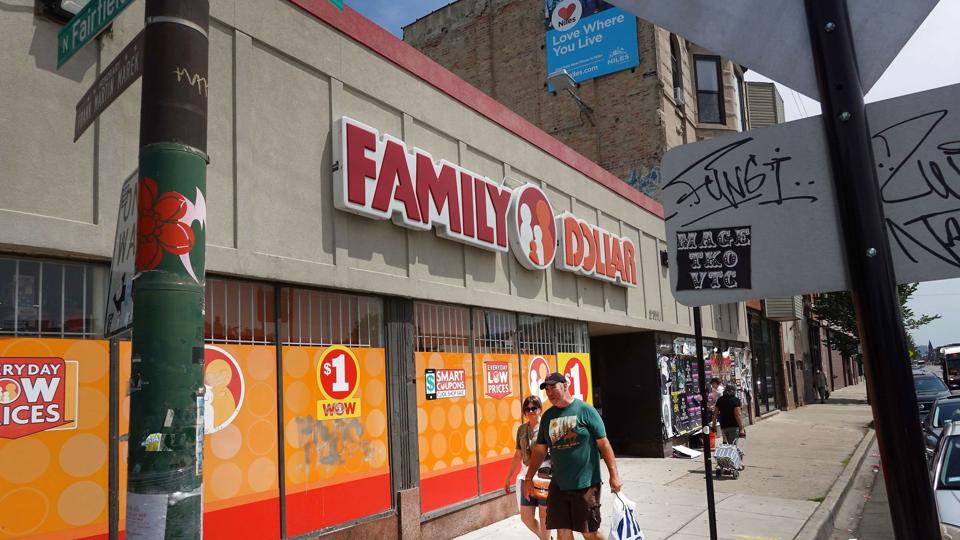 Fodgængere med indkøbsposer går forbi en afdeling af butikskæden Family Dollar i den amerikanske by Chicago. Inflationen gør dybe indhug i de fleste amerikaneres købekraft. <i>Scott Olson/Ritzau Scanpix</i>