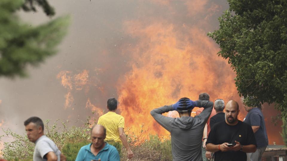 Lokale indbyggere betragter skovbranden i byen Añón de Moncayo i det nordøstlige Spanien. Otte landsbyer og mindst 1500 mennesker er blevet evakueret fra Zaragoza-provinsen, hvor flere hundrede brandfolk kæmper for at få kontrol med branden. <i>Fabian Simon/Ritzau Scanpix</i>