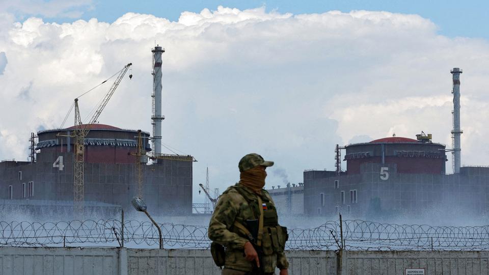 Soldat med russisk flag holder vagt ved det ukrainske atomkraftværk Zaporizjzja. Ruslands forsvarsministerium siger torsdag, at værket vil blive lukket ned, hvis ukrainske styrker fortsætter med at sende granater mod det. <i>Alexander Ermochenko/Reuters</i>