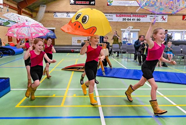 Lillespring piger i festlig indmarch med paraplyer og røjsere. Foto: Ole Iversen