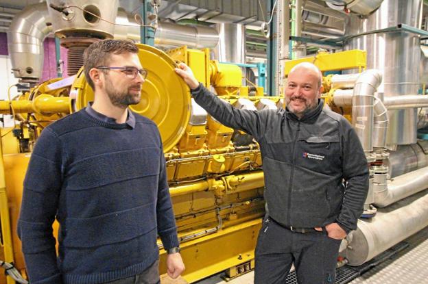Formand for Dronninglund Fjernvarme, Svend B. Bøgh, og driftsleder Casper Christiansen ved en af de store motorer på kraftvarmeværket på Tidselbak Allé i Dronninglund. Foto: Jørgen Ingvardsen