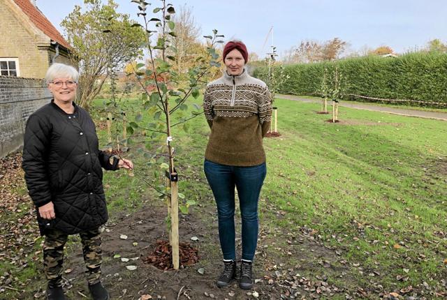 Bestyrelsesmedlemmer i støtteforeningen Annette Dyrbye og Michelle Bentzon viser de nyplantede æbletræer i haven. Foto: Kirsten Olsen