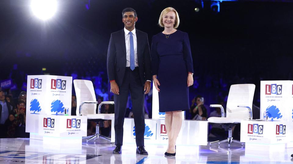 Sunak og Truss står ved siden af hinanden med store smil under sidste debat op til ledervalg i Det Konservative Parti i Storbritannien. <i>Hannah Mckay/Reuters</i>