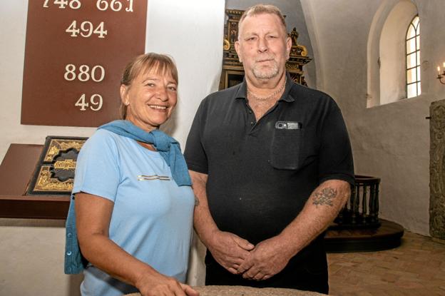 Kjeld Thorsen Sørensen sammen med sognepræst Inger Øeby Pedersen ved døbefonten i Haverslev kirke, hvor han blev døbt som 52-årig for syv år siden. Foto: Jesper Hansen