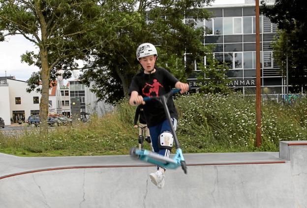 Thomas Noritaka Andersen viser, hvordan løbehjulet skal hele vejen rundt om styret, mens han svæver i luften. Foto: Hans Sejlund