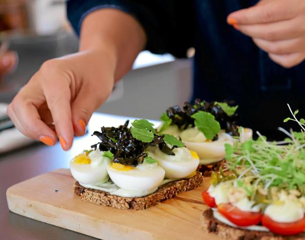 Her serverer Katrine tomatmad med ramsløgsmayo, syltet strandarve, hasselnødder og skud fra Roligheden, Skagens Gårdbutik, og en æggemad med wasabimayo, mynte og sprød blæretang. Foto: Vibe Maria Dahl Andersen