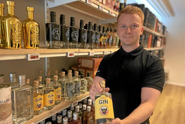 Daniel Granding Sloth, butikschef hos Hobro Vinhandel, med den nye Hobro IK Gin. Foto: Jesper Bøss