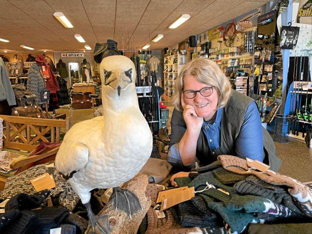 Vita Juul kan fejre 20 år i spidsen for Hadsund Jagt & Fritid. Til venstre ses en udstoppet Sule, der gik i et net i Mariager Fjord og som nu står i butikken. Foto: Jesper Bøss