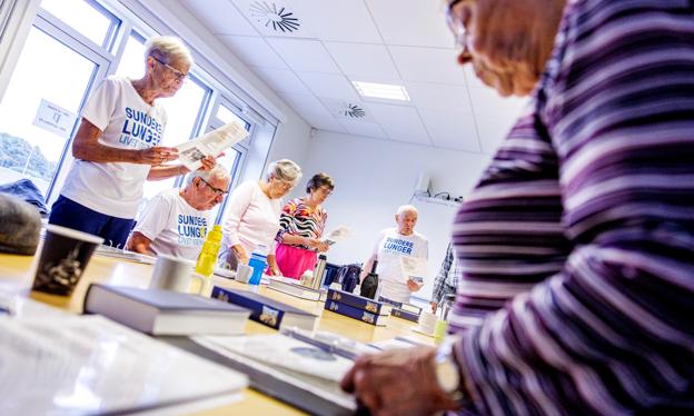 Brønderslev Lungekor sidder rundt om et bord, når de synger - og dem, der kan, står op til nogle af sangene. <i>Foto: Torben Hansen</i>