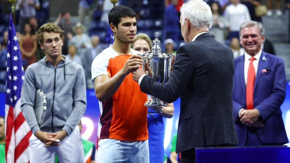 Carlos Alcaraz fik overrakt US Open-trofæet af den amerikanske tennislegende John McEnroe. <i>Mike Segar/Reuters</i>