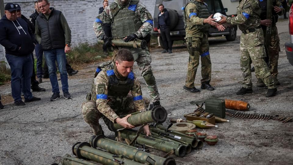 Ukrainsk militærpersonale sorterer ueksploderede miner og våben i byen Udy i Kharkiv-regionen, efter at Ukraine har generobret byen. <i>Gleb Garanich/Reuters</i>