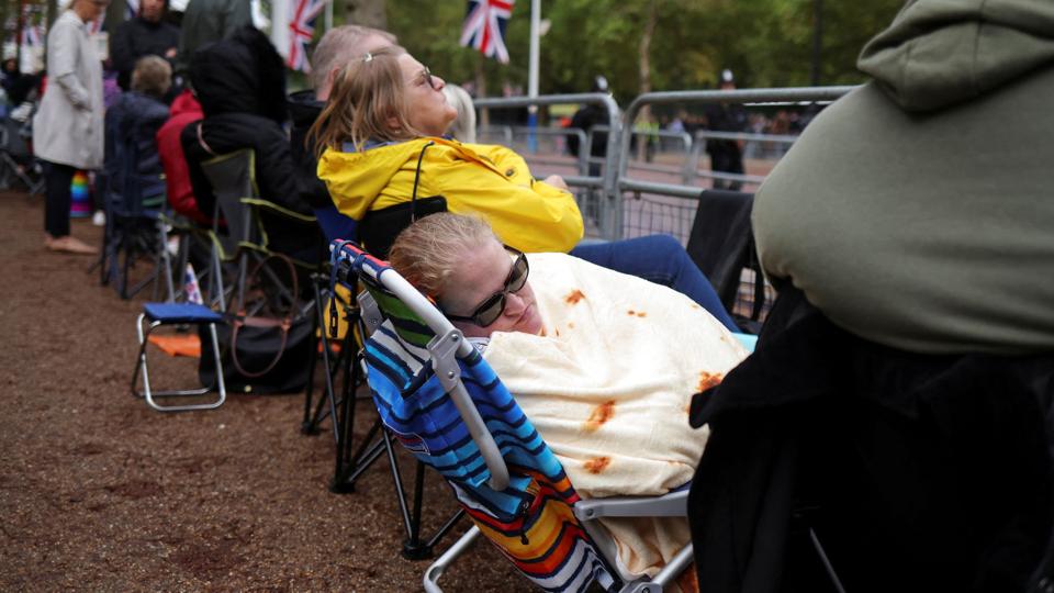 Trofaste royalister har sikret sig første række på boulevarden The Mall med Buckingham Palace for enden. Onsdag eftermiddag passerer en kanonvogn med den afdøde dronning Elizabeths kiste. Den skal til parlamentet, hvor den skal ligge castrum doloris. Op mod trekvart million briter ventes her at kunne sige et personligt farvel til dronningen. <i>Kevin Coombs/Reuters</i>