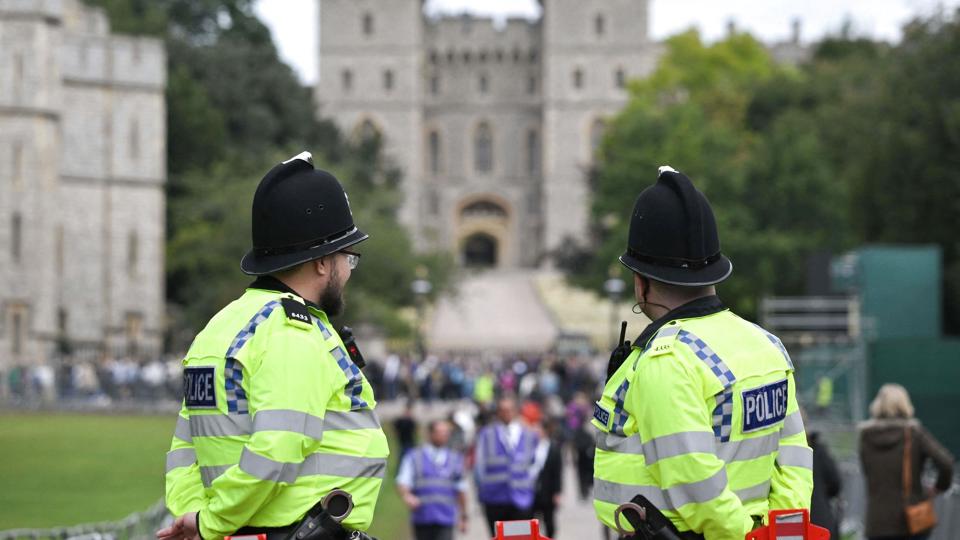 Politibetjente ved slottet Windsor vest for London, hvor dronning Elizabeth stedes til hvile ved siden af sin mand prins Philip, der døde i april sidste år, 99 år. <i>Loic Venance/Ritzau Scanpix</i>