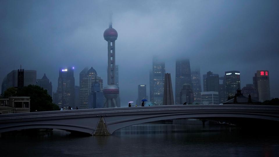 Folk med paraply krydser en bro under et uvejr, som kom til Shanghai med en tyfon. 1,6 million mennesker er blevet evakueret. <i>Aly Song/Reuters</i>