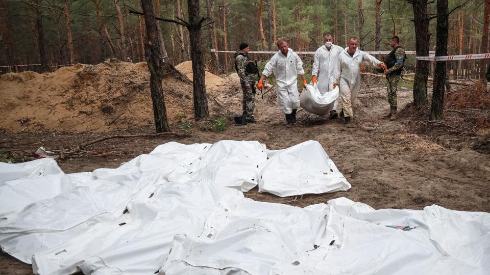 Politi og retsmedicinere er ved at udgrave de hundredvis af lig, der ligger i massegrave i skovene udenfor byen Izjum i det nordøstlige Ukraine. <i>Gleb Garanich/Reuters</i>