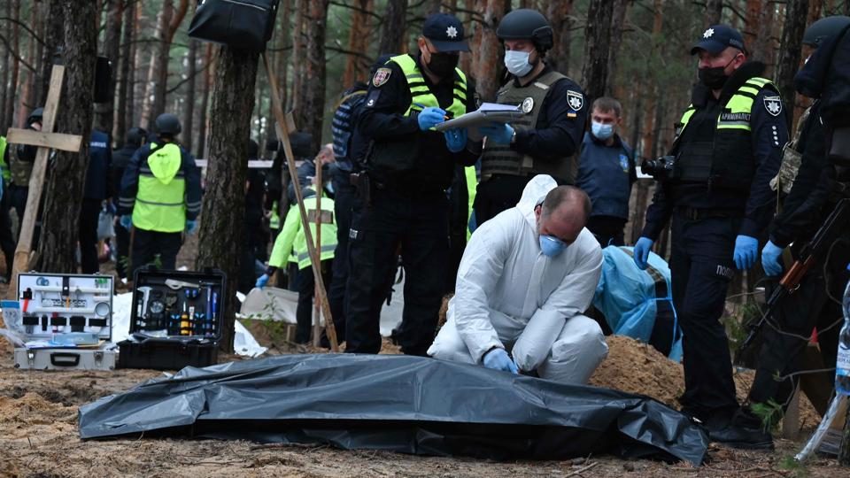 En retsmedicinsk tekniker lukker en ligpose med en af de hundredvis af døde, der er fundet i en massegrav i skovene udenfor byen Izjum i det østlige Ukraine. <i>Sergey Bobok/Ritzau Scanpix</i>