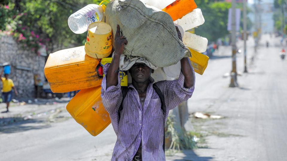 Haitianere går flere kilometer for at fylde dunke med vand i Port-au-Prince. Protester har forsinket og standset distributionen af vand. <i>Ralph Tedy Erol/Reuters</i>