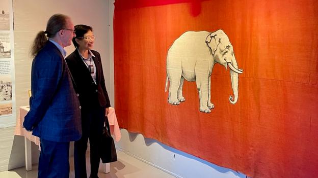 Direktør for Nordjyllands Kystmuseum, Henrik Gjøde Nielsen, viser Elefantflaget til den thailandske ambassadør til Danmark, fru Sirilak Niyom. <i>Foto: Nordjyllands Kystmuseum</i>