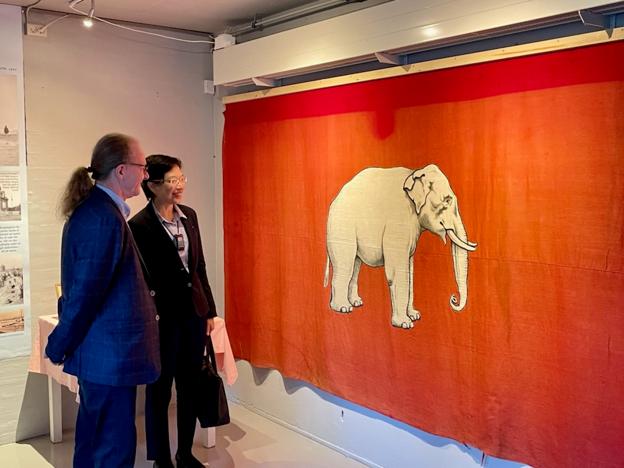 Direktør for Nordjyllands Kystmuseum, Henrik Gjøde Nielsen, viser Elefantflaget til den thailandske ambassadør til Danmark, fru Sirilak Niyom. <i>Foto: Nordjyllands Kystmuseum</i>