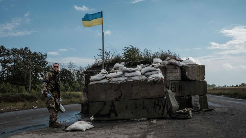 En soldat står her ved en kampvogn og et ukrainsk flag i et generobret område i Kharkiv. <i>Yasuyoshi Chiba/Ritzau Scanpix</i>