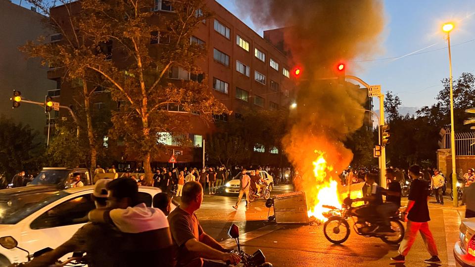 En brændende motorcykel ses her under protester mandag i Teheran. <i>Wana News Agency/Reuters</i>