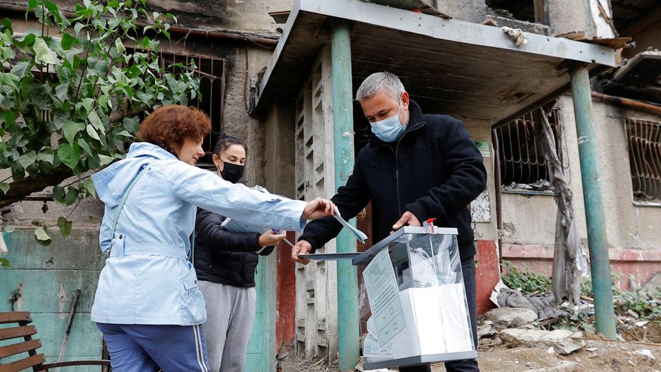 Et medlem af en lokal valgkommission går rundt med en mobil valgboks i Mariupol i Donetsk i Ukraine, hvor der er en russisk-organiseret folkeafstemning om at blive russere. <i>Alexander Ermochenko/Reuters</i>