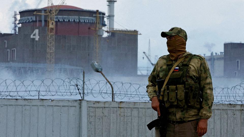 En soldat med et russisk flag på sin uniform holder vagt ved det ukrainske atomkraftværk Zaporizjzja. Russiske soldater har nu tilbageholdt generaldirektøren for det ukrainske atomkraftværk, oplyser ukrainske medier. <i>Alexander Ermochenko/Reuters</i>