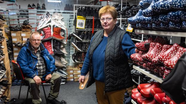 Jane Jepsen har 27.000 par sko i butikken, som kunderne kan vælge imellem. Her hjælper hun Søren Grønby med at finde et par. <i>Foto: Henrik Bo</i>