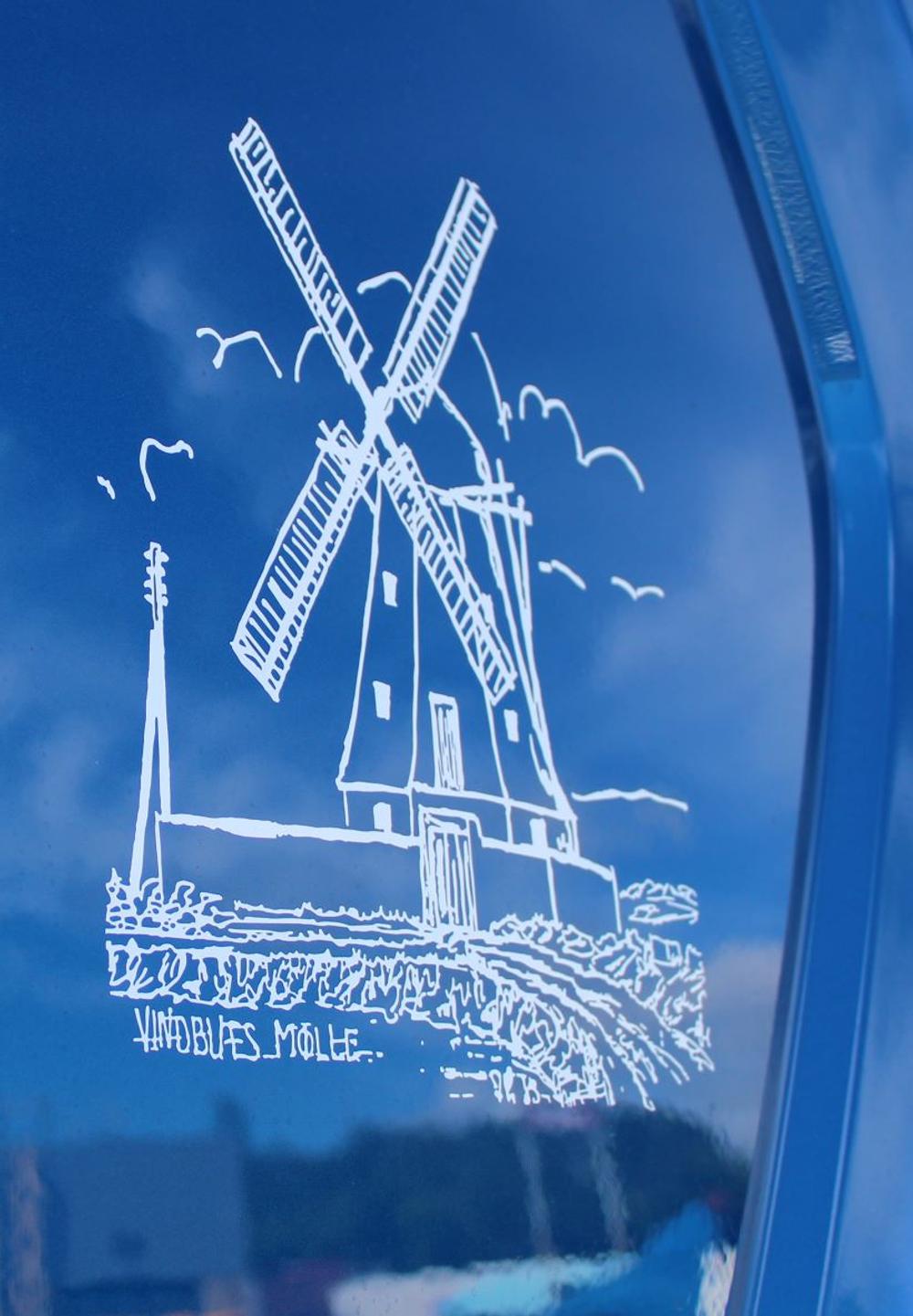 På en bakketop står Vindblæs Mølle og skuer ud over bølgende kornmarker. Nu er den foreviget på vognmandens nye bil. Foto: Stiholt. På en bakketop står Vindblæs Mølle og skuer ud over bølgende kornmarker. Nu er den foreviget på vognmandens nye bil. Foto: Stiholt.
