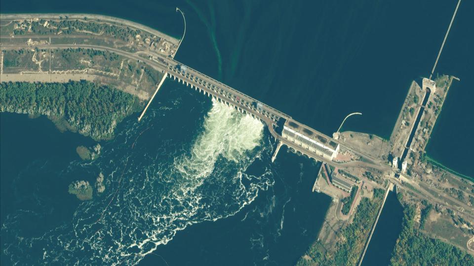 Satellitfoto af den russisk-kontrollerede Nova Kakhovka-dæmning i Ukraine. Dæmningen meldes søndag delvist ødelagt ved et granatangreb udført af ukrainske styrker. Det rapporterer det russiske nyhedsbureau Tass. <i>Maxar Technologies/Reuters</i>