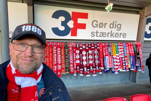 Lars Hvilsted foran et udpluk af halstørklæderne på 3F-tribunen på Aalborg Portland Park.