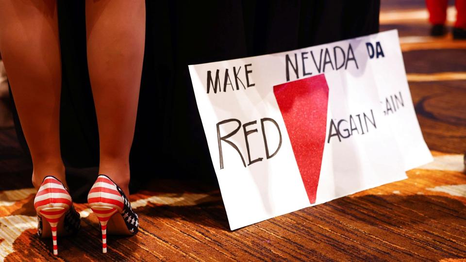 I Nevada står valget til Senatet mellem Demokraternes Catherine Cortez Masto, som vandt en plads i Senatet i 2016 og dermed er på genvalg nu, og Republikanernes Adam Laxalt. Her bærer en af Laxalts støtter et par højhælede sko med det amerikanske flag på og et skilt med teksten "Make Nevada red again" ved et valgarrangement i Nevada. <i>Mario Tama/Ritzau Scanpix</i>