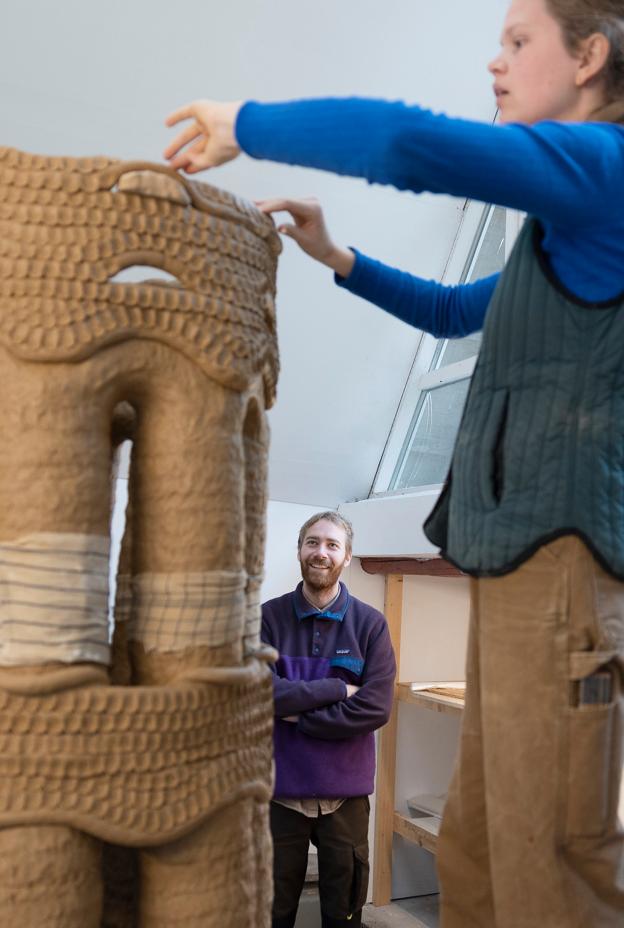 Karoline Bach Larsen arbejder på skulpturen, mens hendes kæreste, Lasse Buus Jensen, ser til. Han, der er nyuddannet arkitekt, har tilbragt en måned på Kirsten Kjærs Museum sammen med Karoline sønnen Ebbe på otte måneder.