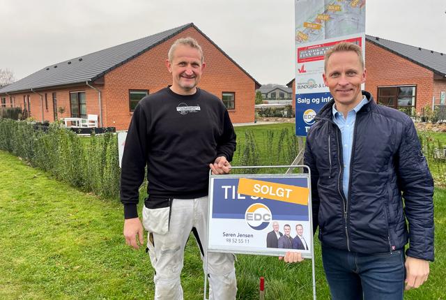 Finn Sørensen og Thomas Jensen ved skiltet, der viser at alle seks rækkehuse er solgt.