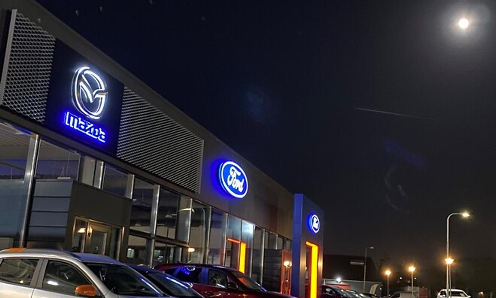 Bild tagen under natten på en en bilförsäljare av Mazda Ford Bild tagen under natten på en en bilförsäljare av Mazda Ford
