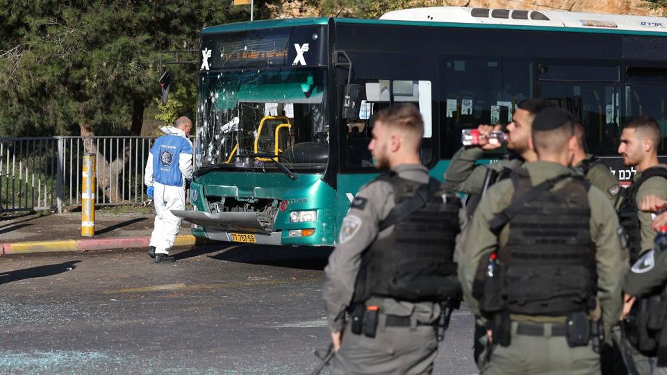Israelske sikkerhedsstyrker er samlet ved en bus, der er beskadiget efter en eksplosion ved et busstoppested ved indgangen til Jerusalem onsdag morgen. <i>Ahmad Gharabli/Ritzau Scanpix</i>
