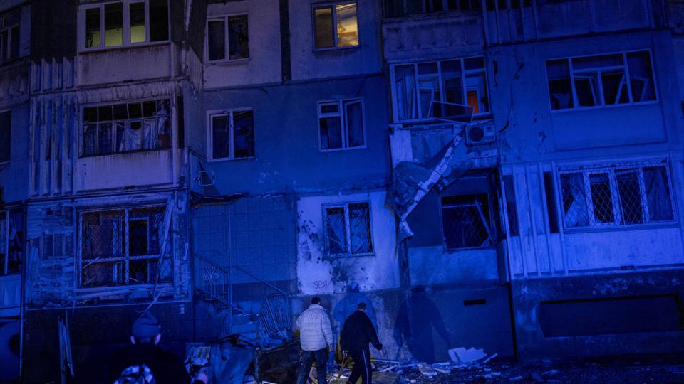 En borger går mellem murbrokker torsdag aften efter et russisk angreb på byen Kherson. <i>Bernat Armangue/Ritzau Scanpix</i>