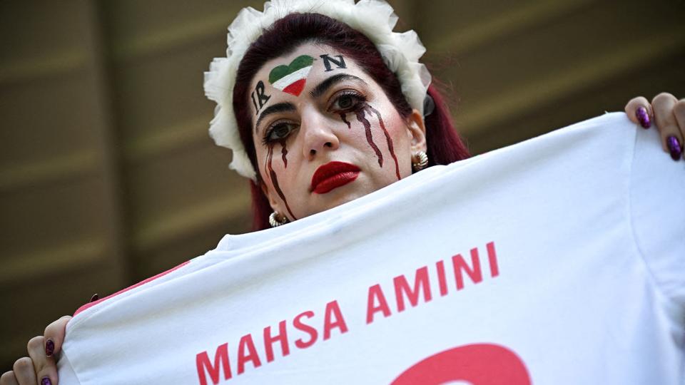 En kvinde holder her en trøje foran sig med Mahsa Aminis navn. Det var den 22-årige kvinde, der i september døde i det iranske moralpolitis varetægt. <i>Dylan Martinez/Reuters</i>