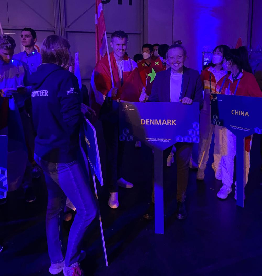 Gry Astrup Hansen og hendes danske holdkammerater står blandt de andre landes deltagere før indgangsceremonien.