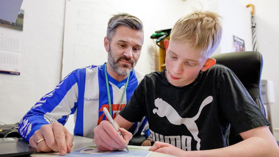 Træner John Skov og elev Magnus Snerle viser, hvordan det gik for sig, da Magnus skrev kontrakt. <i>Foto: Torben Hansen</i>