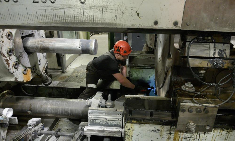 Den store presse trykker med 2400 tons tryk. Her står pressen stille, mens Sten Andersen er ved at reparere nogle dele. Den store presse trykker med 2400 tons tryk. Her står pressen stille, mens Sten Andersen er ved at reparere nogle dele.