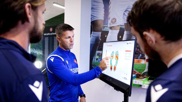 AaB's chef-fysioterapeut Morten Skjoldager tegner og forklarer her et nyt digitalt værktøj til at måle spillernes fysiske belastning gennem fødderne. <i>Foto: Torben Hansen</i>